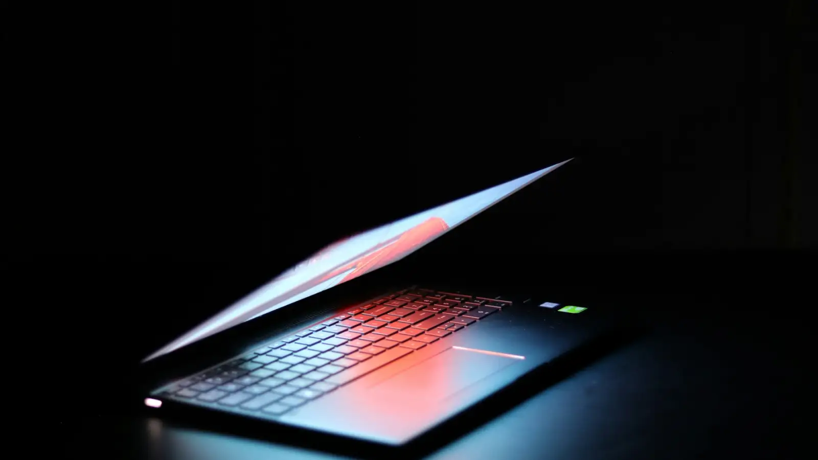 A laptop glowing in a dark room